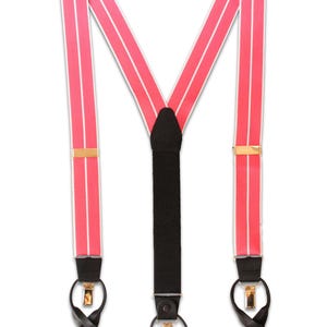 Puede incluir: Tirantes rosas con rayas blancas y herrajes dorados. Los tirantes tienen presillas de cuero negro y una correa trasera de tela negra. Un accesorio clásico para vestimenta formal o informal.