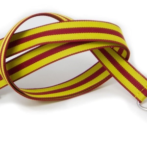 May include: A yellow and maroon striped lanyard with a black plastic clip and a silver swivel hook.