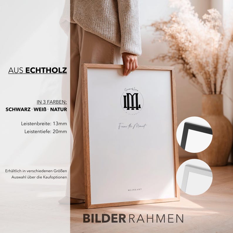 May include: A wooden picture frame with a white mat and a black logo. The frame is held by a person. The frame is available in black, white, and natural wood. The frame's dimensions are 13mm wide and 20mm deep. The text on the frame says "Frame the Moment."
