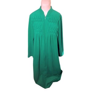 May include: A long, emerald green robe with a high collar and long sleeves. The robe features a full-length zipper and decorative pleated and textured panels on the chest. The robe is displayed on a mannequin.