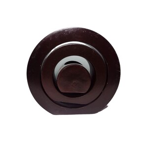 Peut inclure: Un puzzle en bois brun fonc&eacute; avec des cercles concentriques. Le puzzle est compos&eacute; de trois pi&egrave;ces qui s'embo&icirc;tent pour cr&eacute;er un design unique.