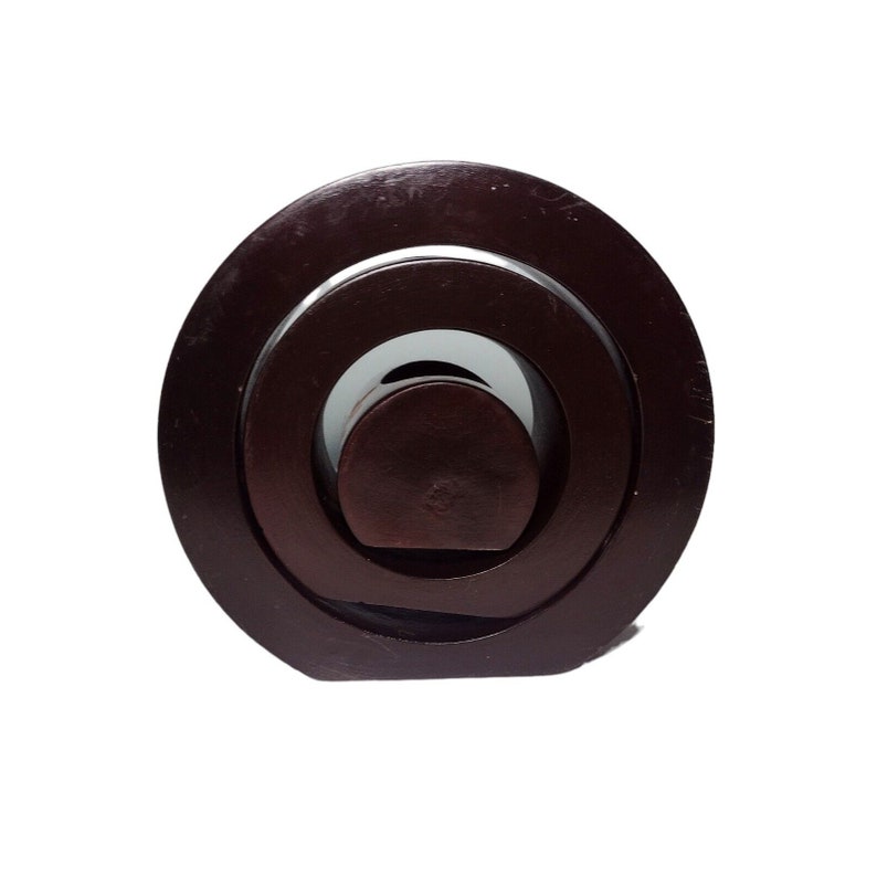 Peut inclure: Un puzzle en bois brun fonc&eacute; avec des cercles concentriques. Le puzzle est compos&eacute; de trois pi&egrave;ces qui s'embo&icirc;tent pour cr&eacute;er un design unique.