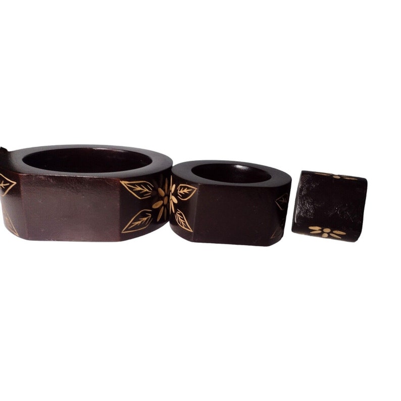 Peut inclure: Ensemble de trois anneaux de serviette en bois avec une finition brun fonc&eacute; et des motifs floraux dor&eacute;s.