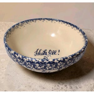 以下が含まれることがあります： クリーム色の内側と青い斑点のある縁を持つセラミックボウル。 「That's All!」という言葉がボウルの中に青い筆記体で書かれています。 ボウルはおそらく食べ物を提供するのに使用されます。