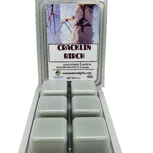 May include: Six white wax melts in a clear plastic clamshell container. The label on the front of the container reads "Cracklin Birch" and "Hand-poured Scented Wax Melts" with a website address. The label also states "Made in Georgia, USA" and "Net Wt. 2.5 oz".