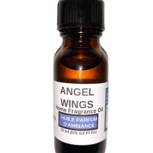 Op de afbeelding: Een bruine glazen fles met een zwarte dop. Het etiket vermeldt "ANGEL WINGS Home Fragrance Oil" en "HUILE PARFUM D'AMBIANCE 15 ml (US 1/2 Fl Oz)".