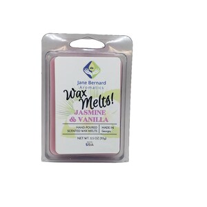May include: A pink wax melt in a clear plastic container. The label reads "Jane Bernard Aromatics Wax Melts! Jasmine & Vanilla" and "Hand-poured Scented Wax Melts Made in Georgia Net Wt. 2.5 oz (113g) USA".