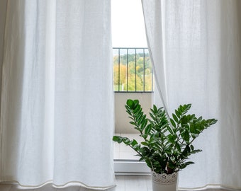 Puede incluir: Cortinas blancas y transparentes con vista a los árboles y un balcón a través de la ventana. Una planta verde en maceta se encuentra en el suelo frente a la ventana.