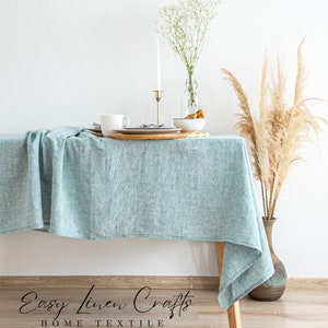a table with a blue table cloth and a vase with a plant on it