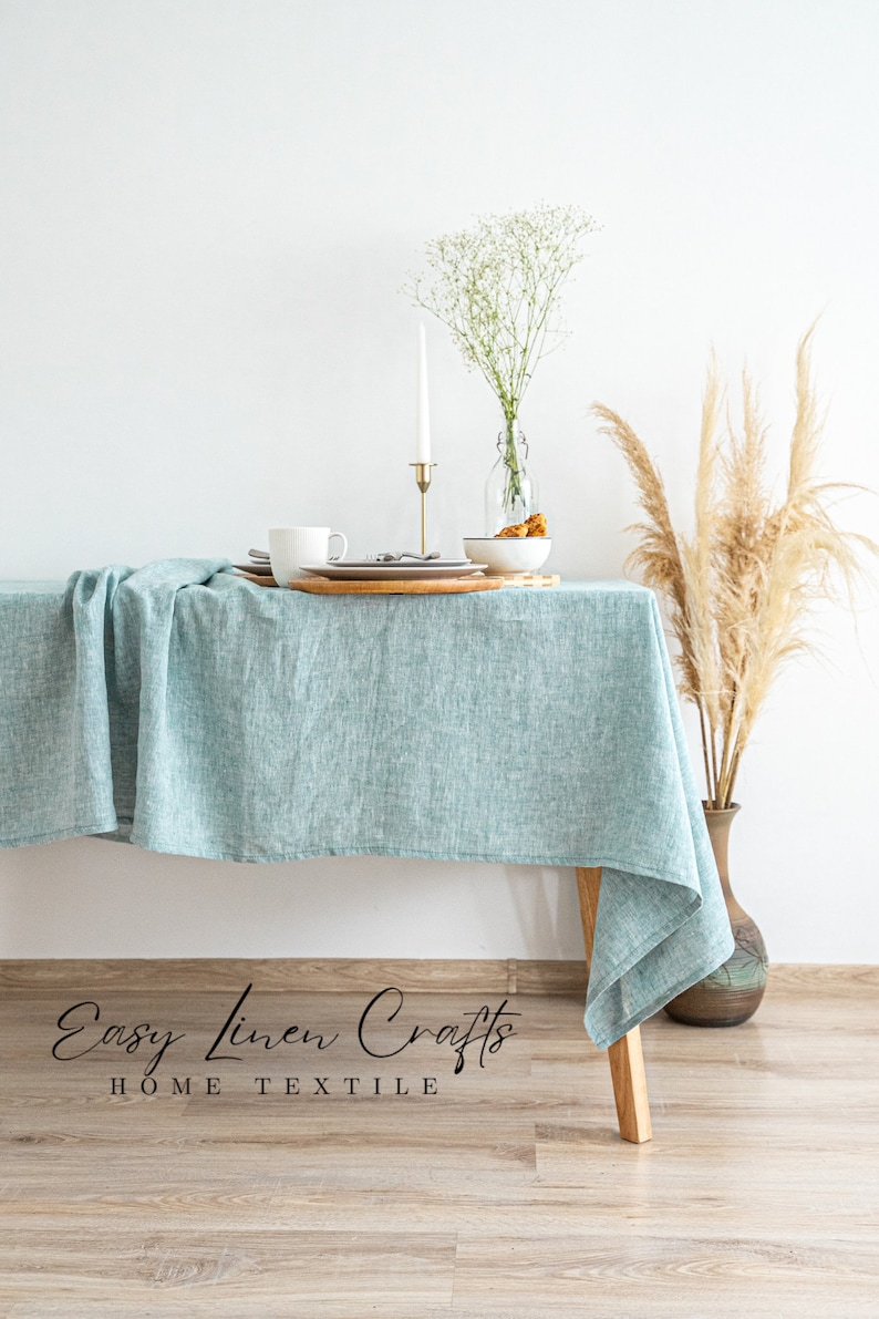 a table with a blue table cloth and a vase with a plant on it