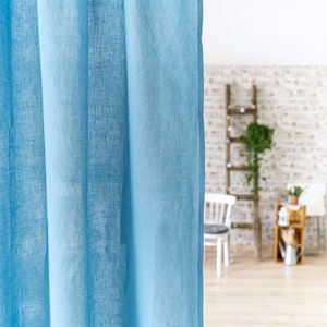 May include: A light blue linen curtain hangs in a room with a wooden ladder and a brick wall in the background. The text "Easy Linen Crafts" is visible at the bottom of the image.