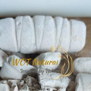 May include: White chalk blocks with the text "WOT Natural Inspired by Nature" in gold lettering. The chalk is broken into pieces and is on a white surface.