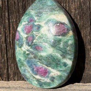 May include: A white ceramic mug with a black handle and the text "But First, Coffee" in a bold, black font. The mug is set against a neutral background, highlighting its simple design.