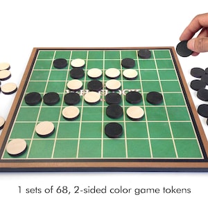 May include: A board game with a green grid, wooden frame, and black and tan game pieces. The game is set up with some pieces on the board, and hands are holding additional pieces. The text at the bottom says "1 sets of 68, 2-sided color game tokens."