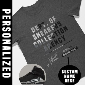 Peut inclure: Un t-shirt gris foncé chiné avec le texte DEPT. OF SNEAKERS COLLECTION AGENCY, MEMBER ID: CHROME EIGHT et AUTHENTIC FINDS. Un graphique circulaire montre une basket montante noire avec une semelle blanche et grise. Un cercle noir contient le texte CUSTOM NAME HERE.