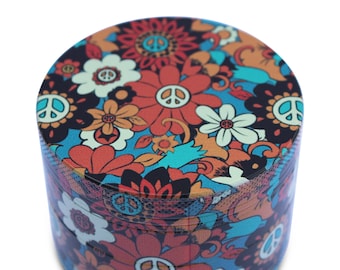 Può includere: Un macinino rotondo in metallo con un design psichedelico colorato con simboli di pace e fiori. Il macinino ha un motivo floreale blu, arancione, rosso e verde.