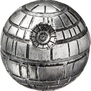 Puede incluir: Un objeto decorativo esf&eacute;rico de color plateado con un dise&ntilde;o detallado que se asemeja a la Estrella de la Muerte de Star Wars.