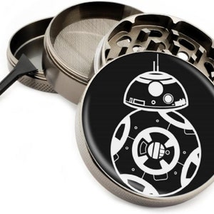 Puede incluir: Un molinillo de metal plateado con un dise&ntilde;o en blanco y negro del personaje de Star Wars BB-8. El molinillo tiene una malla, un compartimento para hierbas y un compartimento para recoger kief.