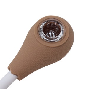 Puede incluir: Una pipa para fumar de silicona marrón con una cazoleta de vidrio. La pipa tiene una superficie texturizada y una boquilla blanca.
