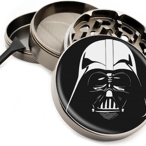 Puede incluir: Un molinillo de metal plateado con una imagen en blanco y negro de la cara de Darth Vader en la tapa.