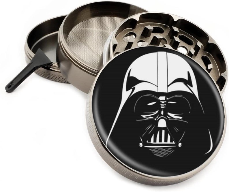 Puede incluir: Un molinillo de metal plateado con una imagen en blanco y negro de la cara de Darth Vader en la tapa.