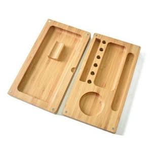 May include: Two-piece wooden rolling tray with multiple compartments. The tray is made of light brown bamboo wood and has a smooth finish. The tray has a large rectangular compartment, a smaller rectangular compartment with multiple slots, and a round compartment.