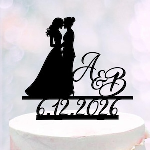 Può includere: Cake topper a silhouette nera con due figure in abito da sposa, rivolte l'una verso l'altra. Il topper include le iniziali "A&B" in corsivo e la data "6.12.2026" sottostante, perfetto per un matrimonio omosessuale.