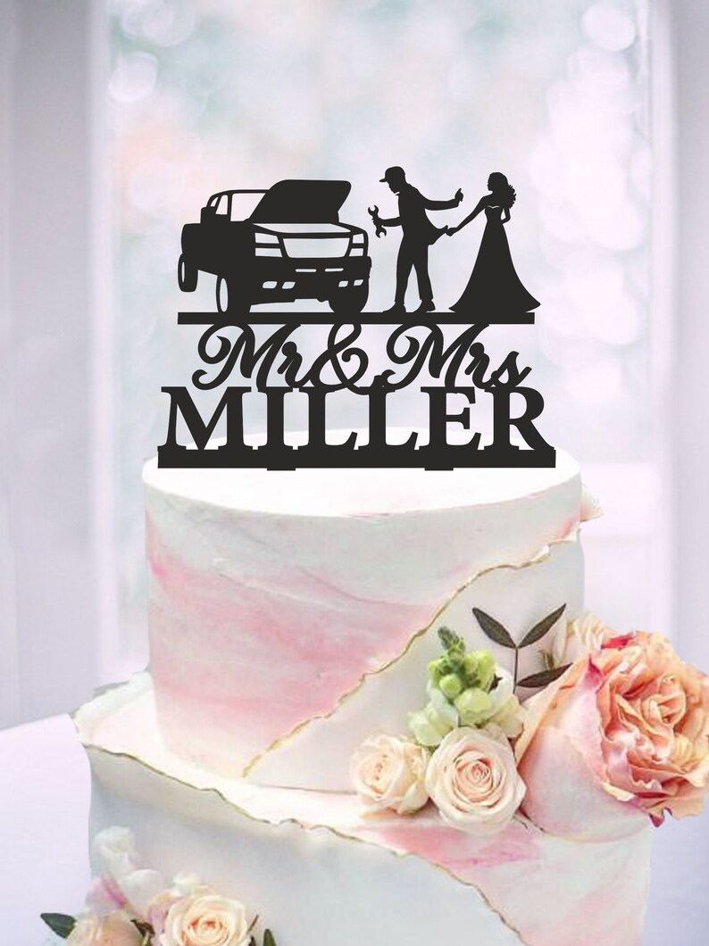 May include: Black silhouette cake topper featuring a couple, a truck, and the text "Mr. & Mrs. MILLER".