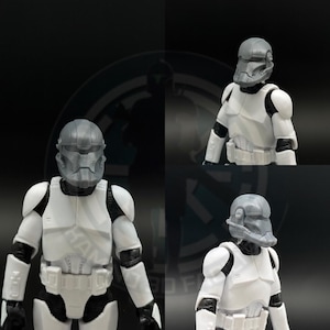 Op de afbeelding: Een wit en zwart actiefiguur van een personage met een grijze helm en harnas. Het figuur staat in een dynamische pose, met gedetailleerd harnas en een helm. De afbeelding is een compositie van meerdere weergaven van hetzelfde figuur.