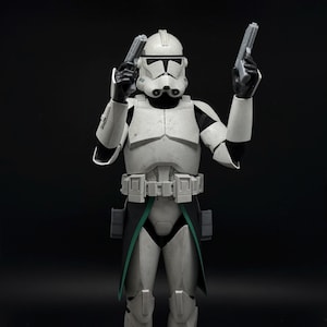 May include: A white ceramic mug with a black handle and the text "But First, Coffee" in a bold, black font. The mug is set against a blurred background, suggesting a cozy setting.