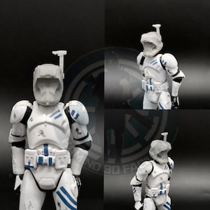 May include: White action figure of a clone trooper with a blue and white helmet and armor. The figure has a blue and white stripe pattern on the legs and arms. The figure is holding a blaster rifle.