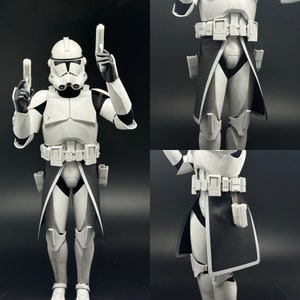 Peut inclure: Une figurine d'action blanche et noire d'un stormtrooper avec une cape noire et deux blasters. La figurine est posée avec un blaster dans chaque main.