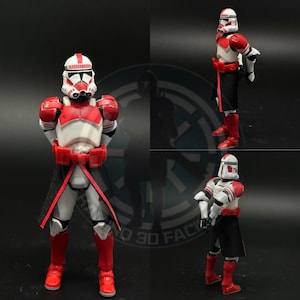 Peut inclure: Une figurine d'action Star Wars rouge et blanche avec une cape noire et une armure rouge et blanche. La figurine est debout, les bras croisés.