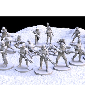 Puede incluir: Colección de figuras en miniatura de soldados en poses de combate. Las figuras son de color gris claro y están sobre bases circulares, sobre un paisaje nevado y texturizado. Algunas figuras están de pie, otras arrodilladas o tumbadas.