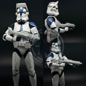 Può includere: Una action figure di Star Wars bianca e blu di un clone trooper. La figura tiene in mano un fucile blaster e indossa un elmetto blu con una striscia bianca.