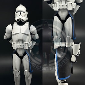 Peut inclure: Figurine détaillée d'un soldat clone, principalement blanche avec des accents noirs et bleus. La figurine porte un casque, une armure et une ceinture utilitaire, et a une cape noire. La figurine est posée avec les mains sur les côtés.