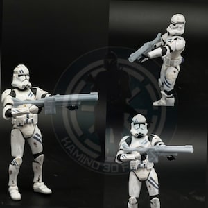 May include: Three white action figures of Star Wars clone troopers, each holding a blaster rifle. The figures are posed in different stances and have battle damage details.