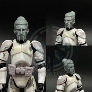 May include: A white and gray action figure with a detailed head sculpt. The figure has a weathered appearance and is wearing a helmet and armor. The head sculpt features a long, braided hairstyle and a beard.