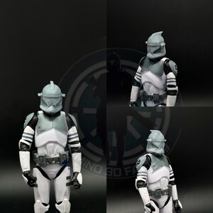 May include: A white and gray action figure of a Star Wars clone trooper with a helmet and a blaster rifle. The figure is posed in a standing position with its arms at its sides.