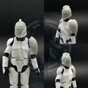 May include: A white and gray action figure of a soldier in armor, with a helmet and shoulder pads. The figure is posed in a standing position, with black gloves and boots. The armor has detailed panels and a utility belt.