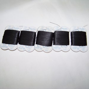 May include: Six spools of black thread, each with a white label that reads "91.44m" and "100% Polyester".