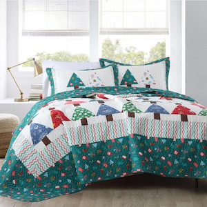 May include: A teal and white Christmas tree patterned quilt set with two matching pillowcases. The quilt features a patchwork design with red, blue, and green accents.