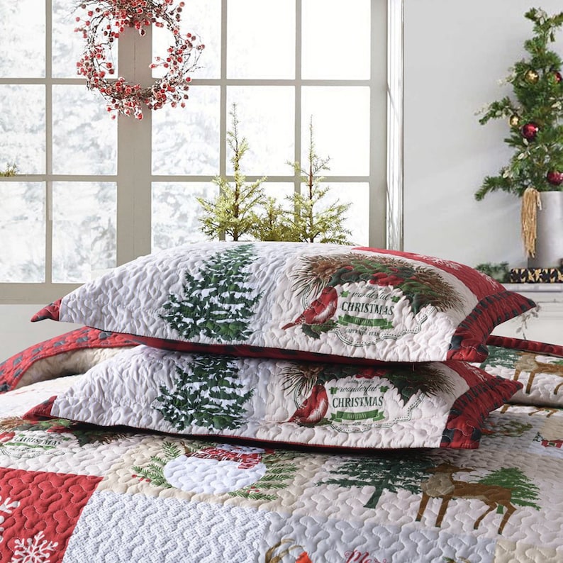May include: Two white and red Christmas themed pillowcases with a quilted design. The pillowcases feature a green pine tree, red cardinals, and the text "A Wonderful Christmas".