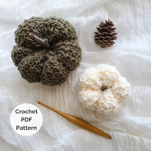 May include: Two crocheted pumpkins, one green and one white, with a wooden crochet hook and a pine cone on a white fabric background. The text "Crochet PDF Pattern" is in a white circle.