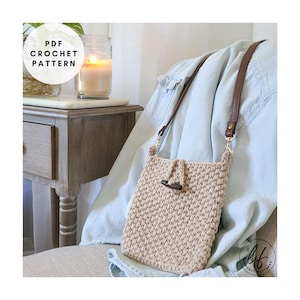 May include: A beige crochet crossbody bag with a brown leather strap and wooden toggle closure. The bag is rectangular and has a textured appearance. The words "PDF CROCHET PATTERN" are in a white circle in the upper left corner.
