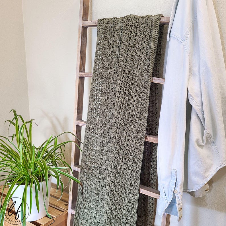 This image shows the crochet rectangle shawl draped over a blanket ladder.