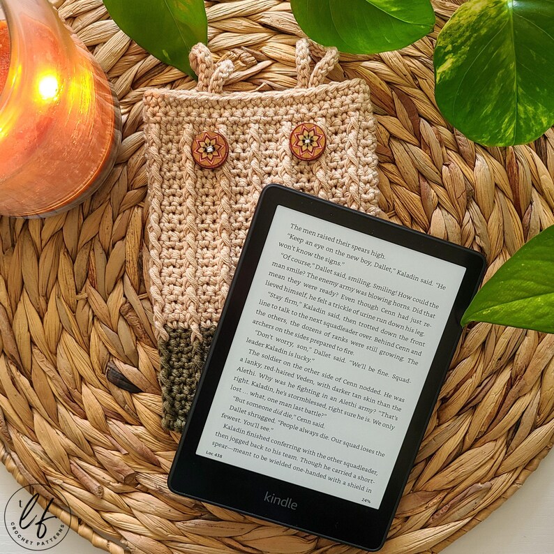 This image shows a kindle sitting on top of a two toned crochet kindle cover, made from this crochet kindle cover pattern.