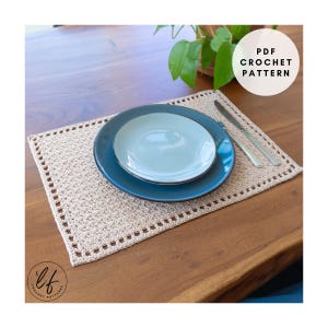 Peut inclure: Un set de table en crochet beige avec une assiette bleue et une assiette bleu clair dessus. Un couteau et une fourchette sont placés à droite des assiettes. Le texte "PDF Crochet Pattern" est dans un cercle blanc.