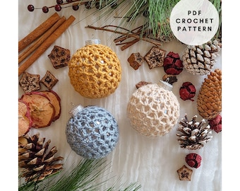 Könnte beinhalten: Handgefertigte gehäkelte Weihnachtskugeln in Gelb, Creme und Blau, arrangiert mit Tannenzapfen, Zimtstangen und Trockenfrüchten. Der Text "PDF Crochet Pattern" ist ebenfalls enthalten.
