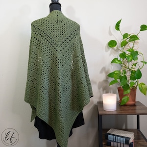 This image shows the crochet triangle shawl pattern sample draped over a mannequin as a women would wear it. The crochet shawl is shown from the back to show details. The crochet wrap is made in olive green yarn.